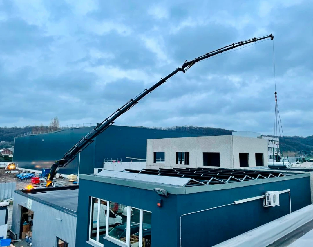 Grue Palfinger RMS8 livrant des matériaux sur toiture